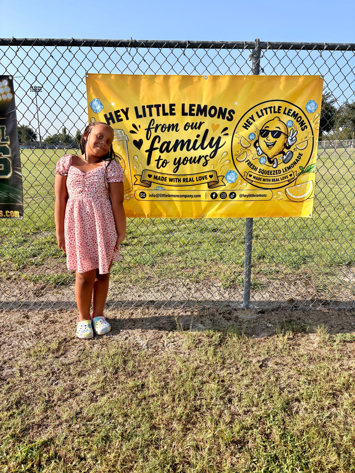 Rylee Washington standing beside the Hey Little Lemons banner reading 'From our family to yours โ made with real love'